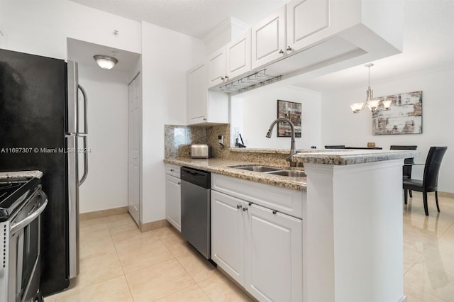 kitchen with an inviting chandelier, sink, appliances with stainless steel finishes, light stone counters, and white cabinetry