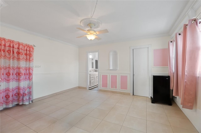 tiled spare room featuring ceiling fan and ornamental molding