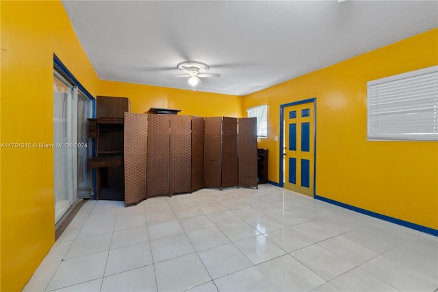 unfurnished room with ceiling fan and light tile patterned flooring