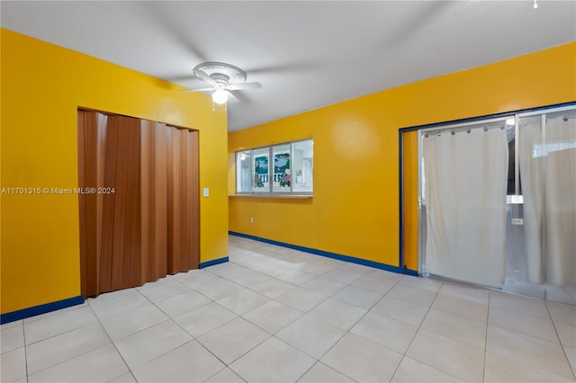 tiled spare room with ceiling fan