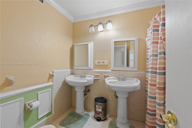 bathroom featuring tile patterned flooring, crown molding, and tile walls