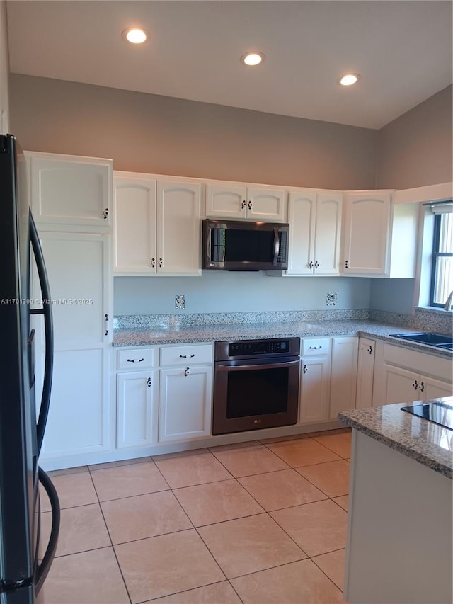 kitchen with white cabinets, light tile patterned flooring, sink, and appliances with stainless steel finishes