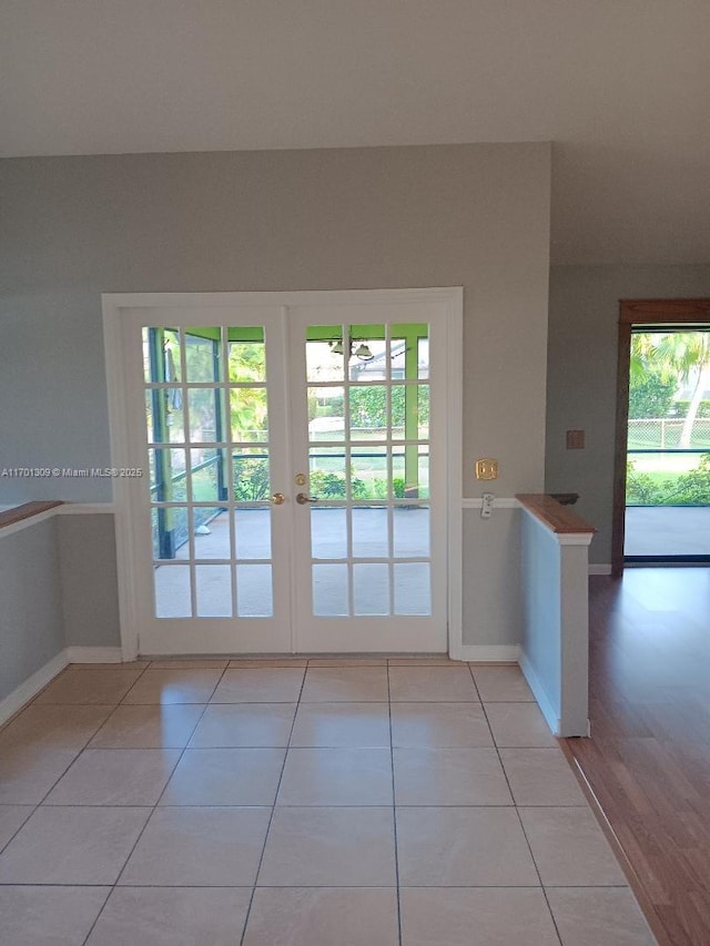 entryway with french doors, light tile patterned floors, and a healthy amount of sunlight