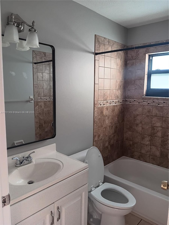 full bathroom with tile patterned floors, tiled shower / bath combo, toilet, and vanity