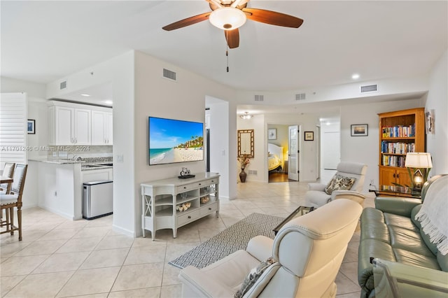 living room with ceiling fan, sink, and light tile patterned floors