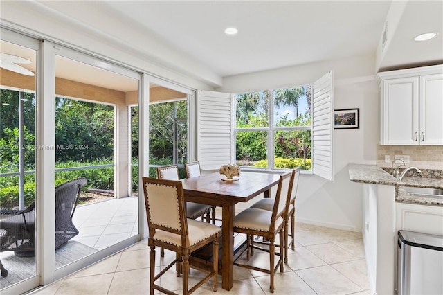 tiled dining room featuring a wealth of natural light and sink