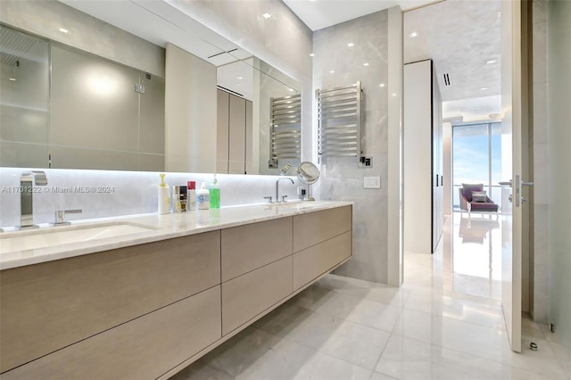 bathroom featuring tile patterned floors, vanity, radiator heating unit, and tile walls