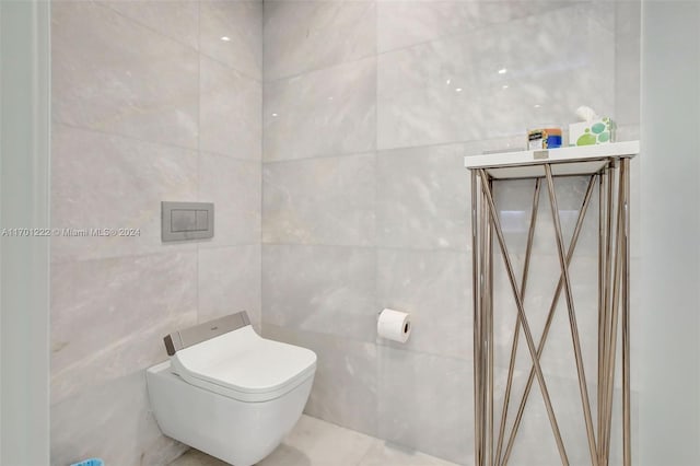 bathroom with toilet and tile walls