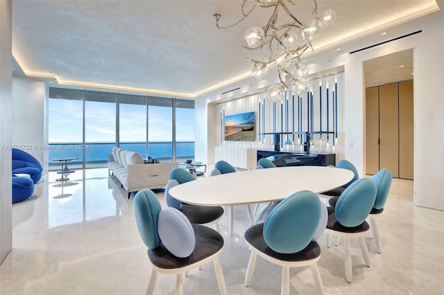 dining room with expansive windows, a water view, and a chandelier