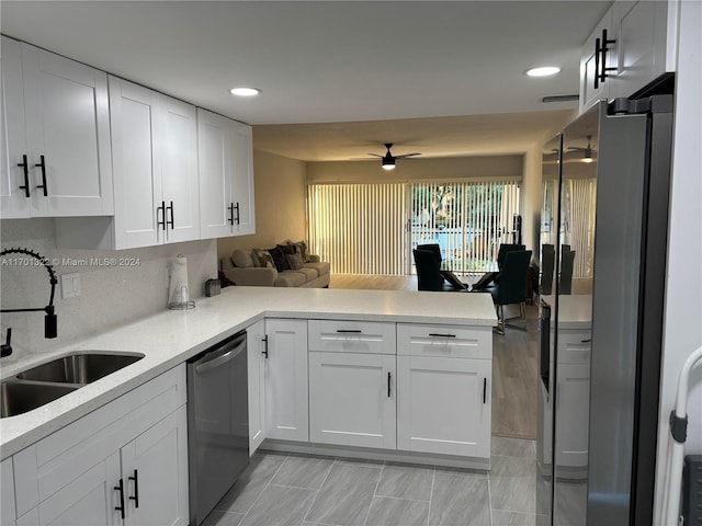 kitchen with white cabinets, stainless steel appliances, kitchen peninsula, and sink