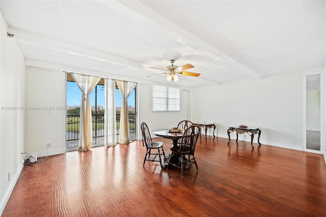 dining area with ceiling fan, beamed ceiling, wood-type flooring, and a textured ceiling