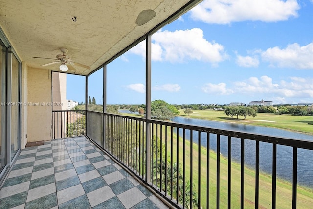 unfurnished sunroom with ceiling fan and a water view