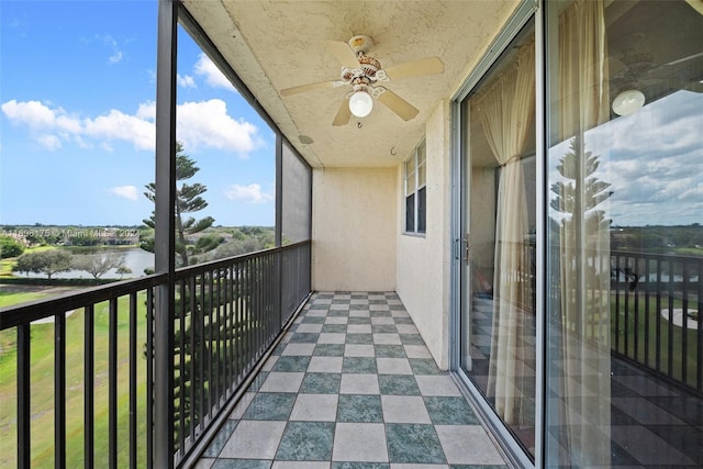 balcony featuring ceiling fan and a water view