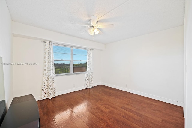 unfurnished room featuring a textured ceiling, ceiling fan, and dark wood-type flooring