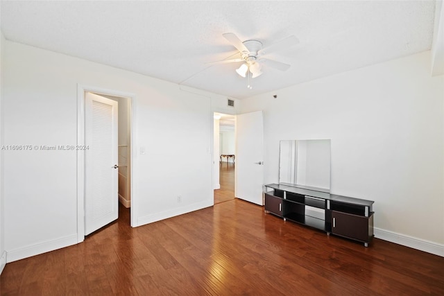 unfurnished bedroom featuring ceiling fan, a closet, and dark wood-type flooring