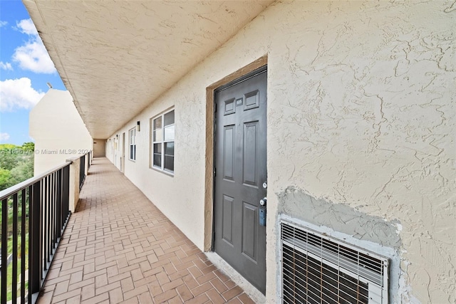 doorway to property with heating unit and a balcony