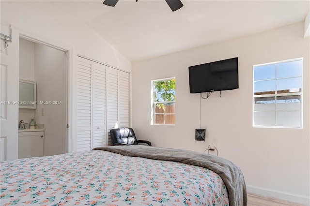 bedroom with ceiling fan, light hardwood / wood-style floors, a closet, and vaulted ceiling