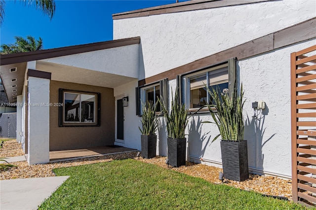 view of exterior entry featuring a yard