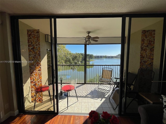 balcony featuring ceiling fan and a water view