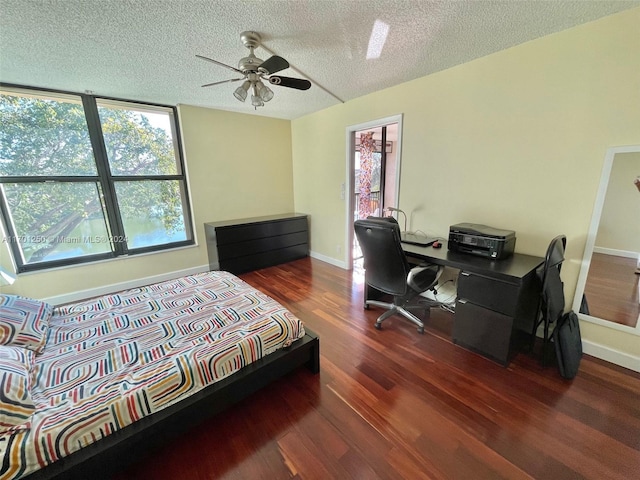 bedroom featuring a textured ceiling, ceiling fan, and dark hardwood / wood-style floors