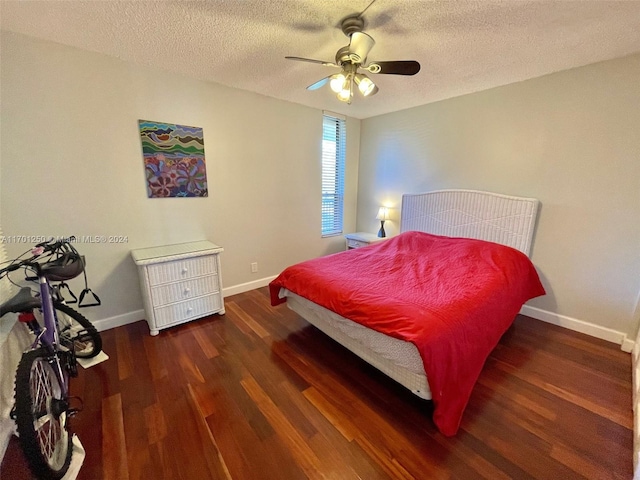 bedroom with dark hardwood / wood-style floors, ceiling fan, and a textured ceiling