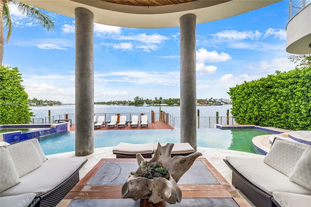 view of pool with outdoor lounge area, a water view, and a patio area