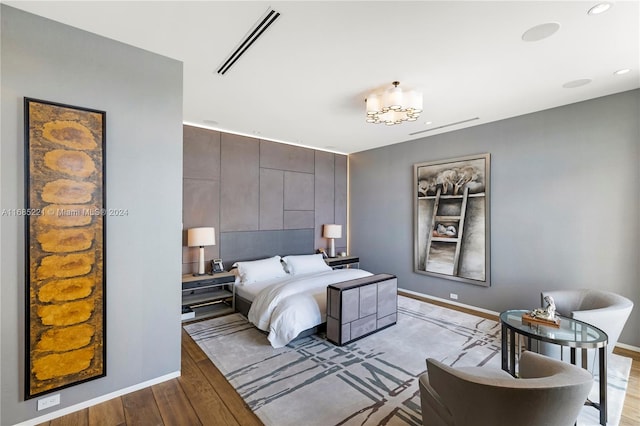 bedroom with a notable chandelier and light hardwood / wood-style flooring