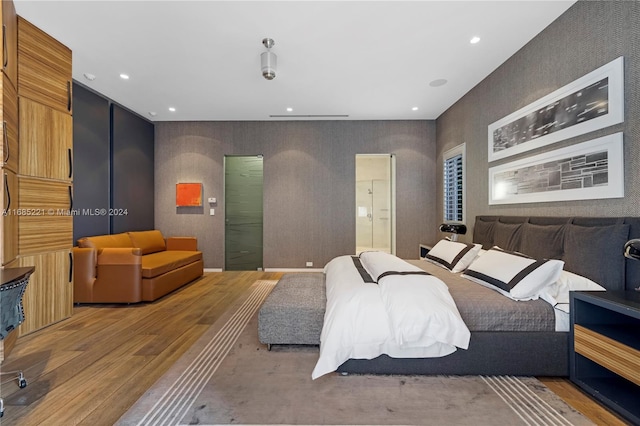 bedroom featuring hardwood / wood-style floors and ensuite bath