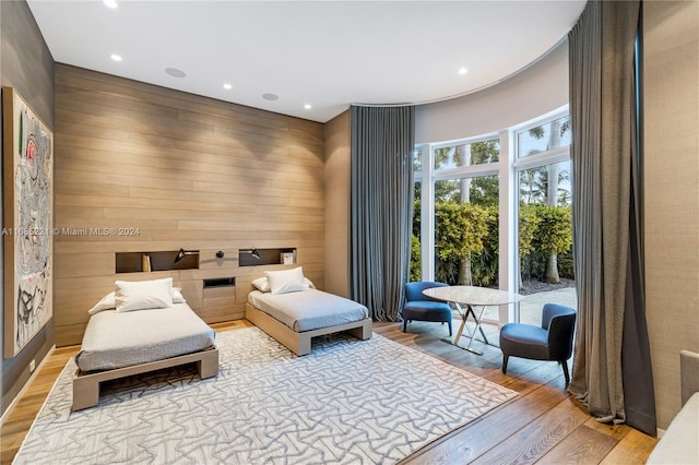 living area with wood walls and light hardwood / wood-style flooring