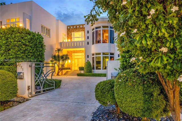 271 N Hibiscus Dr, Miami Beach, FL 33139 - view of front of home featuring stucco siding, a balcony, and driveway