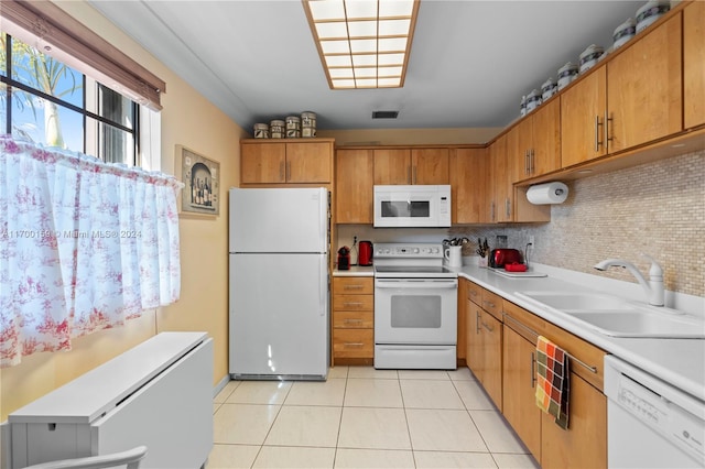 kitchen with decorative backsplash, sink, light tile patterned flooring, and white appliances