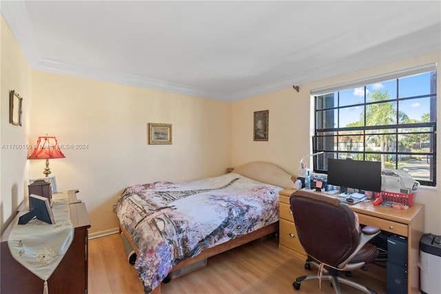 bedroom with light hardwood / wood-style flooring and ornamental molding