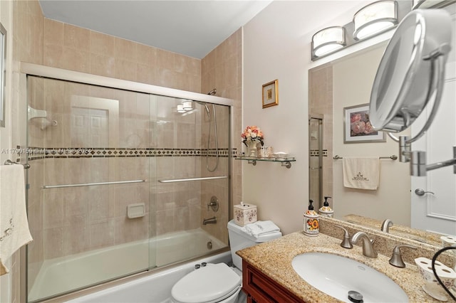 full bathroom featuring vanity, bath / shower combo with glass door, and toilet