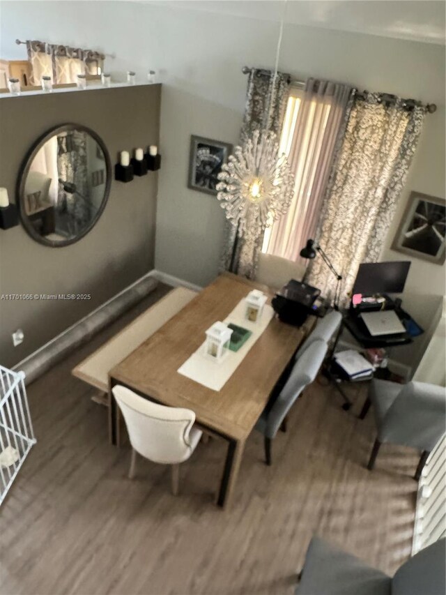 dining room with wood-type flooring and a notable chandelier