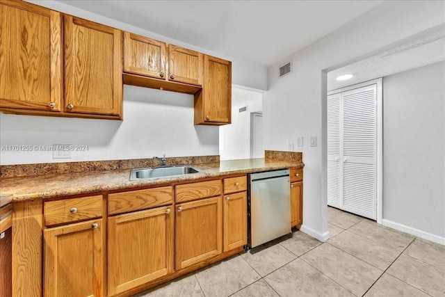 kitchen with stainless steel dishwasher, light tile patterned flooring, and sink