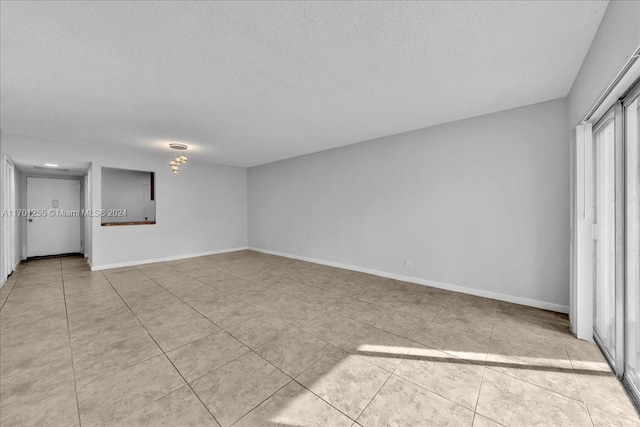 interior space with light tile patterned floors and a textured ceiling