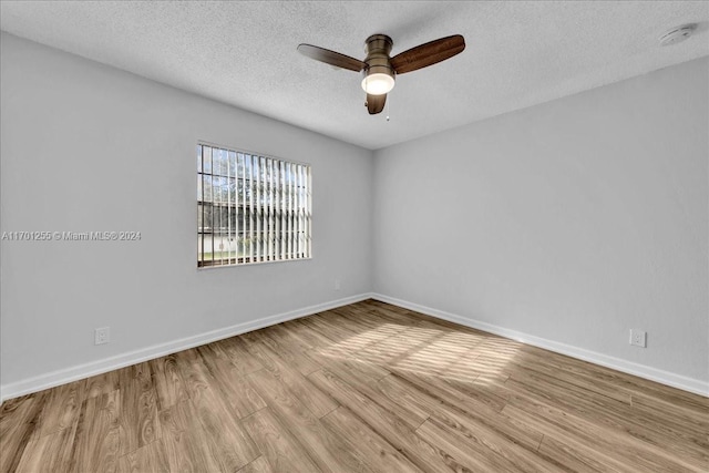 empty room featuring ceiling fan, light hardwood / wood-style floors, and a textured ceiling