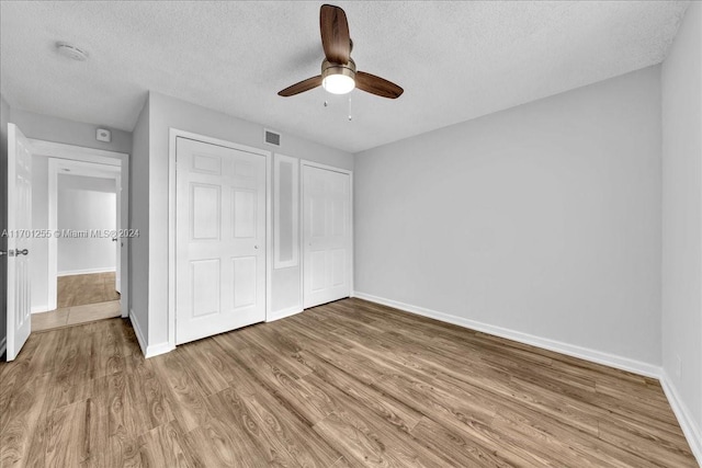 unfurnished bedroom featuring a textured ceiling, hardwood / wood-style flooring, and ceiling fan