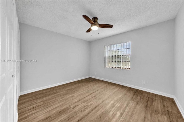 spare room featuring ceiling fan, a textured ceiling, and light hardwood / wood-style flooring