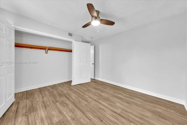 unfurnished bedroom featuring ceiling fan, light hardwood / wood-style floors, a textured ceiling, and a closet