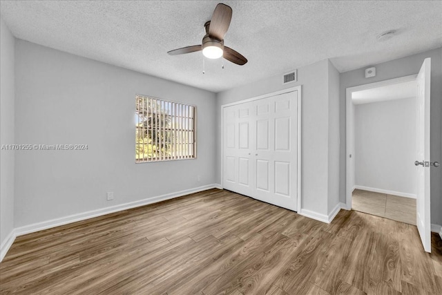 unfurnished bedroom featuring ceiling fan, hardwood / wood-style floors, and a textured ceiling