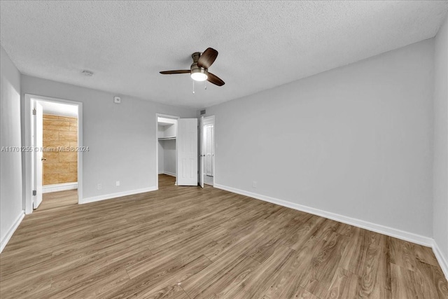 unfurnished bedroom featuring ceiling fan, light hardwood / wood-style floors, a textured ceiling, and a closet