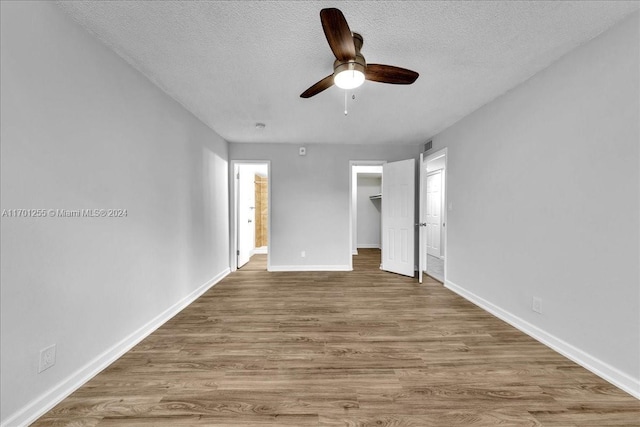 unfurnished bedroom featuring hardwood / wood-style flooring, ceiling fan, and a textured ceiling