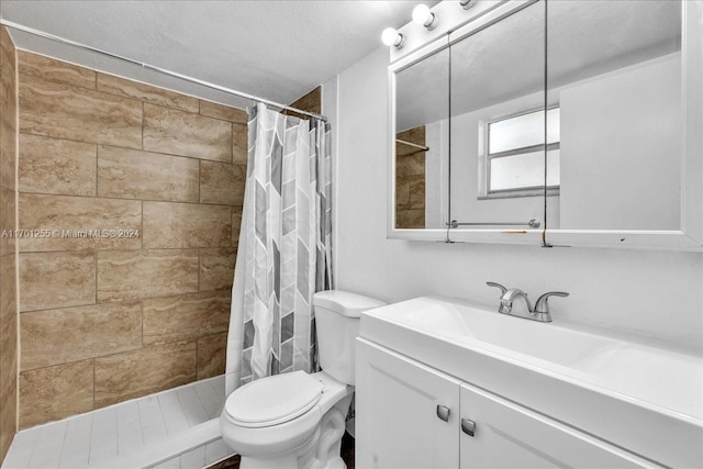 bathroom with a textured ceiling, vanity, toilet, and walk in shower