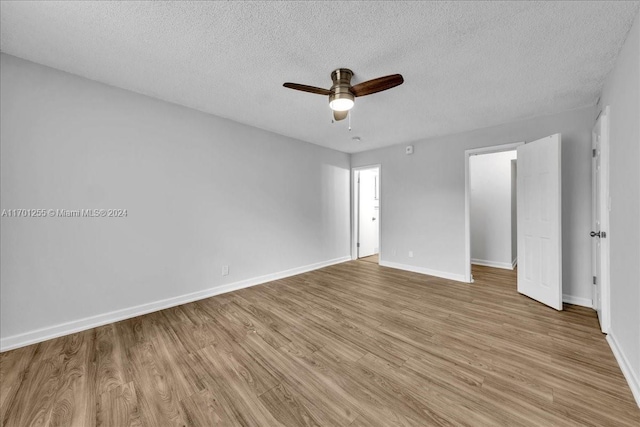 empty room featuring ceiling fan, a textured ceiling, and light hardwood / wood-style flooring