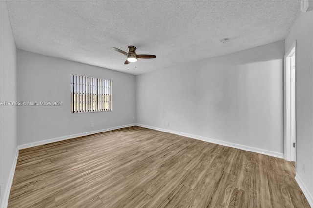 unfurnished room with a textured ceiling, light hardwood / wood-style flooring, and ceiling fan