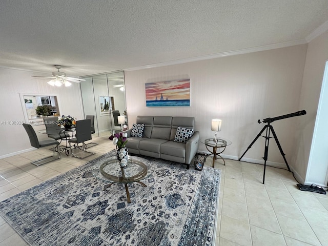 living room featuring ceiling fan, light tile patterned floors, a textured ceiling, and ornamental molding