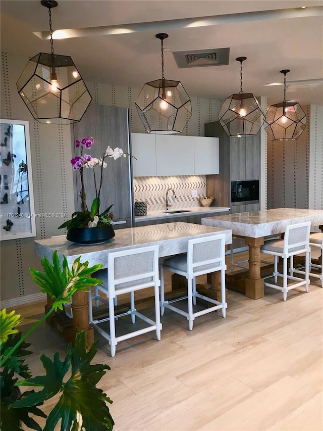 2900 NE 7th Ave Unit 3608, Miami, FL 33137 - kitchen featuring hanging light fixtures, white cabinetry, modern cabinets, and light stone counters