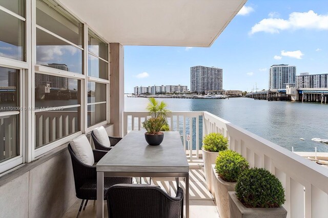 spare room featuring light wood-type flooring, a water view, and a notable chandelier