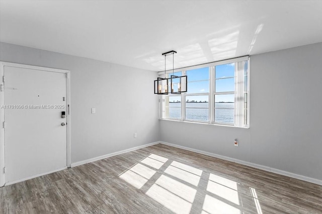 unfurnished dining area featuring light wood-type flooring and a water view